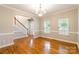 Bright living room with hardwood floors, white trim, and a staircase in view at 132 Homeplace Ln, Statesville, NC 28625