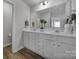 Bathroom features double sinks with white cabinets, a large mirror, and wood-look floors at 149 Briana Marie Way, Indian Trail, NC 28079