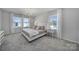 Bright bedroom with large windows, neutral tones, carpet, and a modern chandelier at 149 Briana Marie Way, Indian Trail, NC 28079