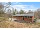 An elevated backyard featuring a brick home, concrete patio, landscaping, and green space at 1525 16Th Avenue Nw Cir, Hickory, NC 28601