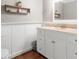 Bright bathroom featuring white wainscotting, vanity with a sink, mirror and open shelving at 1525 16Th Avenue Nw Cir, Hickory, NC 28601