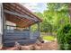 Inviting covered patio with a ceiling fan overlooks the well-manicured backyard and lawn at 1620 Arnold Dr, Charlotte, NC 28205