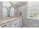 Bright bathroom featuring white vanity with granite countertop and natural light from a window at 1620 Arnold Dr, Charlotte, NC 28205