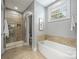 Bright bathroom with a soaking tub and glass-enclosed shower at 1620 Arnold Dr, Charlotte, NC 28205
