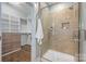 Bathroom with tile shower featuring a built-in niche and adjacent walk-in closet at 1620 Arnold Dr, Charlotte, NC 28205