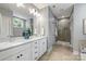 Modern bathroom featuring double sinks, white cabinets, and a glass-enclosed shower at 1620 Arnold Dr, Charlotte, NC 28205
