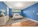 Bright bedroom featuring hardwood floors, blue walls, and a bench at the foot of the bed at 1620 Arnold Dr, Charlotte, NC 28205