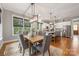 Bright dining area featuring a wooden table, six chairs, pendant lighting, and an open view to the kitchen at 1620 Arnold Dr, Charlotte, NC 28205