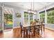 Dining room features wood floors, modern lighting fixture, and multiple large windows overlooking backyard at 1620 Arnold Dr, Charlotte, NC 28205