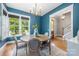 Dining room showcasing a wood table, chandelier, large window, and doorway to a stairway at 1620 Arnold Dr, Charlotte, NC 28205