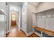 Hallway with a bench, coat hooks, wood floors, and an open doorway with a wooden door at 1620 Arnold Dr, Charlotte, NC 28205