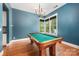 This game room features a billiard table, hardwood floors, and a modern light fixture for a relaxing space to unwind at 1620 Arnold Dr, Charlotte, NC 28205