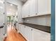 Hallway with hardwood floors and white cabinetry adjacent to gourmet kitchen at 1620 Arnold Dr, Charlotte, NC 28205