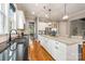 Kitchen with an island and black countertops, leading to a dining area with natural lighting at 1620 Arnold Dr, Charlotte, NC 28205