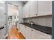 Well-organized pantry space with black countertop and ample cabinet storage, leading to the kitchen and dining area at 1620 Arnold Dr, Charlotte, NC 28205