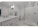 Modern bathroom with glass shower, marble countertop sink, and contemporary lighting fixtures at 1625 Bibury Ln, Charlotte, NC 28211