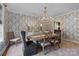 Formal dining room with elegant chandelier, wallpaper, and seating for six at 1625 Bibury Ln, Charlotte, NC 28211