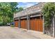 Stone garage with three wooden doors and decorative steel supports, offering ample parking at 1625 Bibury Ln, Charlotte, NC 28211