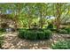 Lush garden featuring a tiered fountain surrounded by manicured boxwoods, gravel, and trees at 1625 Bibury Ln, Charlotte, NC 28211