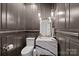 Stylish powder room featuring dark walls, a marble sink, and gold fixtures at 1625 Bibury Ln, Charlotte, NC 28211
