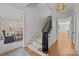 Elegant staircase featuring hardwood floors, a carpet runner, and designer light fixture at 1625 Bibury Ln, Charlotte, NC 28211