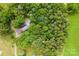 Aerial view showcasing a home surrounded by lush, dense trees, providing privacy and a natural setting at 16453 Nc Hwy 73 Hwy, Albemarle, NC 28001