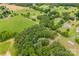 Scenic aerial view of a property featuring a mix of wooded areas and grassy fields at 16453 Nc Hwy 73 Hwy, Albemarle, NC 28001