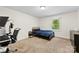 A bedroom with neutral walls and carpet features a bed and desk at 16453 Nc Hwy 73 Hwy, Albemarle, NC 28001