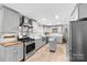 This renovated kitchen features grey cabinetry, stainless steel appliances, and a center island at 16453 Nc Hwy 73 Hwy, Albemarle, NC 28001