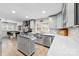 This kitchen features grey cabinetry, stainless steel appliances, white countertops and mosaic tile backsplash at 16453 Nc Hwy 73 Hwy, Albemarle, NC 28001
