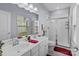 Bright bathroom featuring a double sink vanity, glass enclosed shower, and a window for natural light at 1725 Mill Creek Sw Ln, Concord, NC 28025