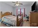 Cozy bedroom with wooden furniture, a ceiling fan, and a bright window, providing a comfortable and inviting retreat at 1725 Mill Creek Sw Ln, Concord, NC 28025