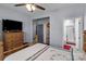 Comfortable bedroom with wooden dresser, TV, ceiling fan, and access to a bathroom, creating a relaxing private space at 1725 Mill Creek Sw Ln, Concord, NC 28025