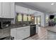 This kitchen offers a sink with granite countertops and modern appliances, connecting to a dining space with natural light at 1725 Mill Creek Sw Ln, Concord, NC 28025