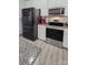 Modern kitchen features stainless steel appliances and sleek black refrigerator complemented by white cabinets at 1725 Mill Creek Sw Ln, Concord, NC 28025