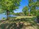 Picturesque backyard with a well-maintained lawn gently sloping toward the serene lake waters at 17835 Terryglass Ln, Charlotte, NC 28278