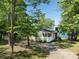 Side view of a quaint home nestled among trees with a view of the lake and a long driveway at 17835 Terryglass Ln, Charlotte, NC 28278