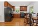 A well-lit kitchen features wood cabinets, a breakfast bar, and stainless steel appliances at 17835 Terryglass Ln, Charlotte, NC 28278