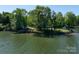 Lakefront property featuring a dock, lake access, and serene views surrounded by lush greenery and mature trees at 17835 Terryglass Ln, Charlotte, NC 28278