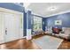 Bright foyer features hardwood floors, white wainscoting, a cozy seating area, and a welcoming front door at 200 Winter Flake Dr, Statesville, NC 28677