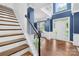 Welcoming foyer with hardwood floors, staircase, white wainscoting, and a beautiful chandelier at 200 Winter Flake Dr, Statesville, NC 28677