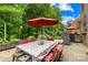 Inviting outdoor dining area with a large table, chairs, umbrella, grill, and views of the lush backyard at 200 Winter Flake Dr, Statesville, NC 28677