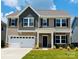 Charming two-story home showcasing a well-manicured lawn, neutral colors, and an attached two-car garage at 2023 Puddle Pond Rd, Indian Trail, NC 28079