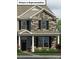 Charming two-story home featuring stone accents, black shutters, and well-manicured landscaping at 2024 Harlequin Dr, Indian Trail, NC 28079