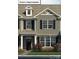 Beautifully designed townhome featuring a stone facade, black shutters, and well-maintained landscaping at 2028 Harlequin Dr, Indian Trail, NC 28079