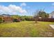 Large backyard featuring lush green grass and partial wood fencing providing privacy and space at 2324 Oakdale Creek Ln, Charlotte, NC 28216