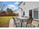 Home's backyard features a patio with outdoor dining and well-maintained lawn and partial fencing at 2324 Oakdale Creek Ln, Charlotte, NC 28216