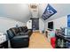 Bonus room features a comfortable black sofa, a modern ceiling fan, and fun Tennessee Titans decor at 2324 Oakdale Creek Ln, Charlotte, NC 28216