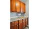 Butler's pantry with wood cabinets, granite countertops, and drink dispensers at 2324 Oakdale Creek Ln, Charlotte, NC 28216