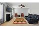 Bright living room featuring fireplace, ceiling fan, and contemporary furnishings, with a view of the staircase at 2324 Oakdale Creek Ln, Charlotte, NC 28216